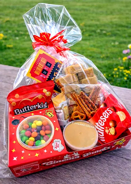 Red snack tray wrapped in cellophane with sweets, pretzels and a dip