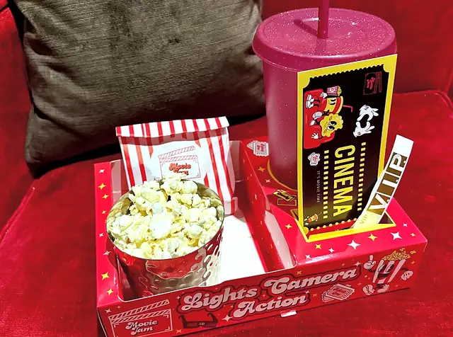 Red snack tray with popcorn, a sweet bag and a cinema ticket cup
